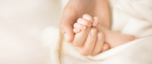 parent and baby holding hands