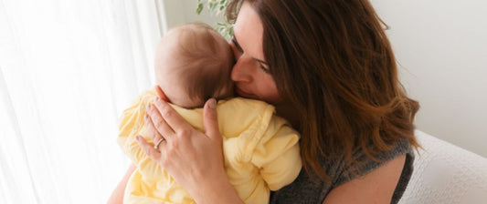 Mum with newborn baby in yellow baby sleeping bag