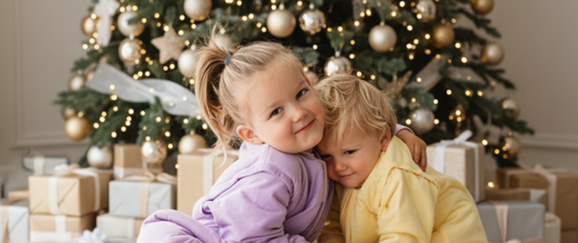 boy and girl in front of the christmas tree