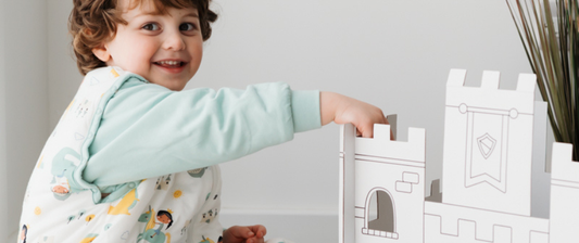 boy in fantasia fairytale sleeping bag playing with a castle