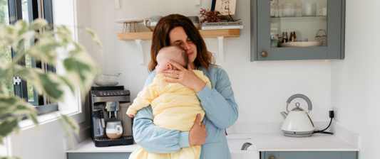 mum cuddling baby in yellow baby sleeping bag
