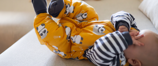 baby sleeping in yellow panda sleeping bag with feet