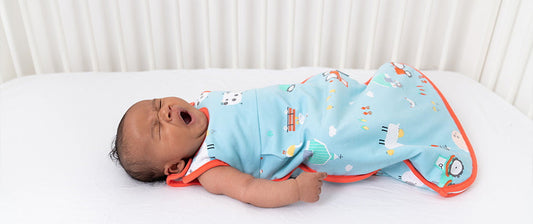 baby yawning in cot in farmyard baby sleeping bag