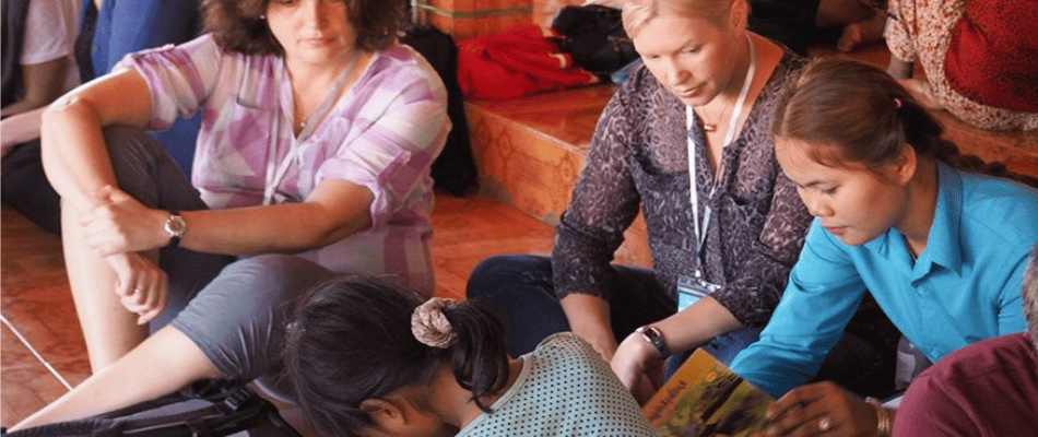 women watching a cambodian lady work 
