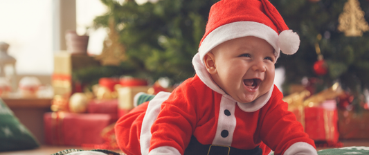 baby dressed in father christmas costume smiling