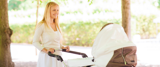 mum pushing baby in park in pram