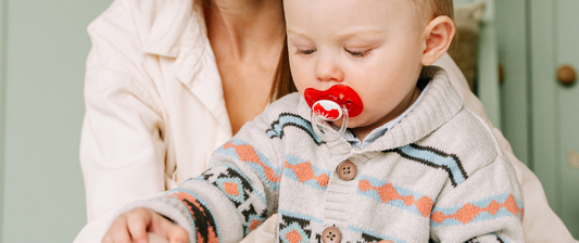 baby with a dummy in their mouth