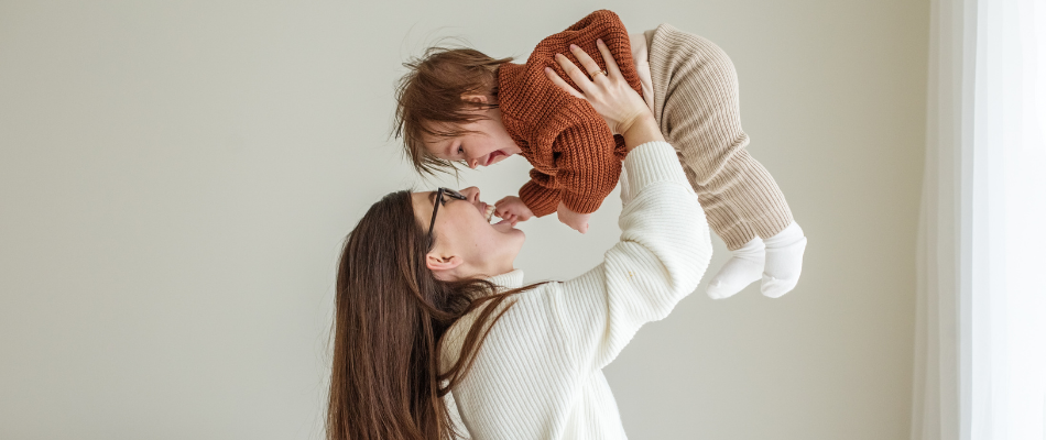 woman holding baby in the air