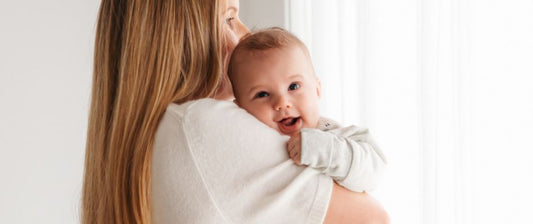 mum cuddling newborn baby in a baby sleeping bag