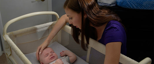 baby in crib with mum looking down