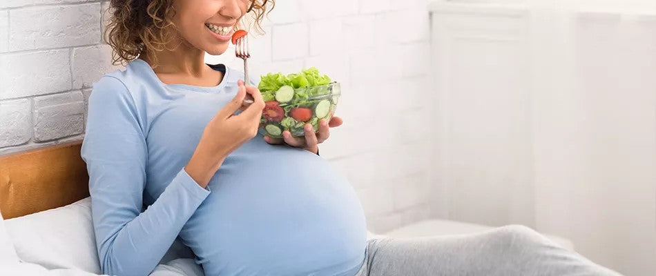 pregnant woman eating salad